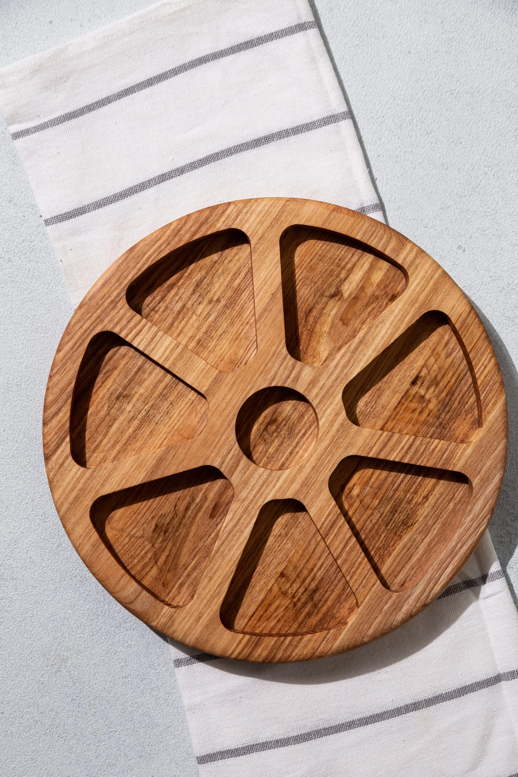 Rundes Serviertablett aus Eiche „Blume“ – Ø 30 cm, 7 Fächer Runde Eichenholzfläche mit Feigen auf weißem Hintergrund